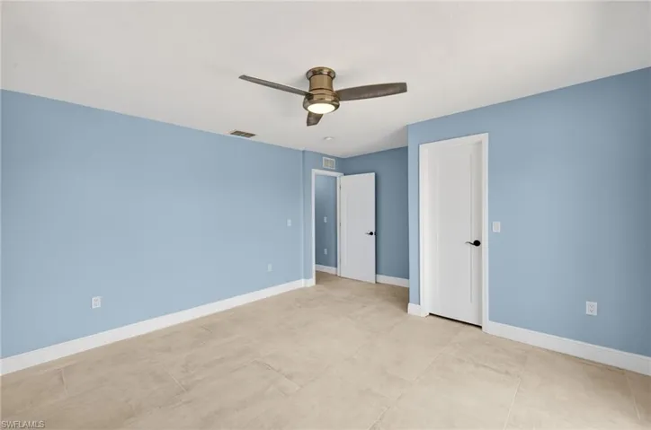 Bedroom #2 featuring light blue walls, ceramic tile flooring, and white baseboards