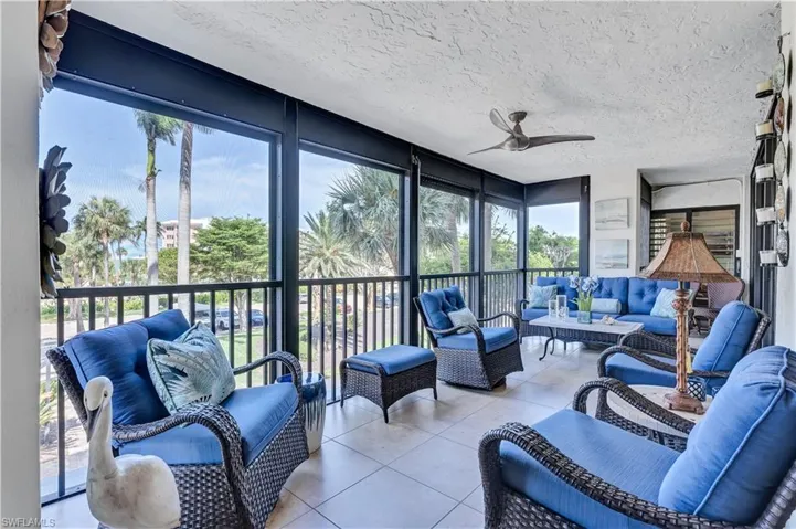 Featuring plenty of natural light, a textured ceiling, floor to ceiling windows, and tile patterned floors