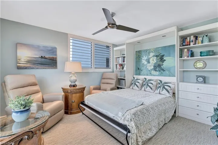 Carpeted den with ceiling fan and Murphy Bed
