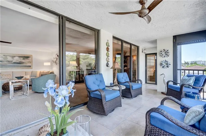 Featuring plenty of natural light, a textured ceiling, floor to ceiling windows, and tile patterned floors