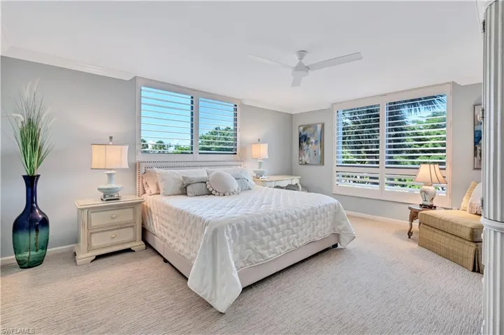 Primary bedroom with crown molding and ceiling fan