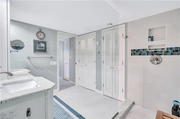 Full Primary bath with a closet, double vanity, and a tile shower