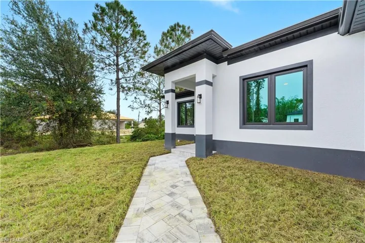 View of exterior entry with a lawn