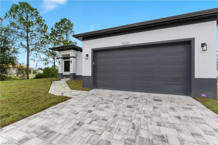 View of front of house featuring a garage and a front lawn