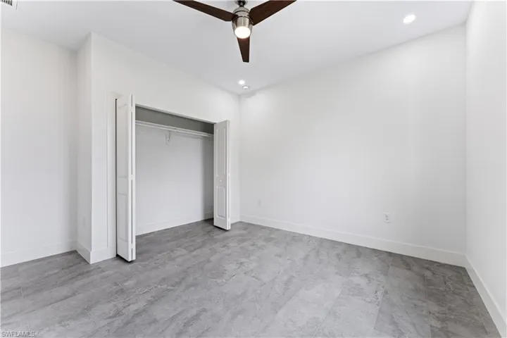 Unfurnished bedroom with ceiling fan and a closet