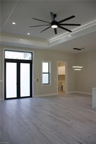 Unfurnished room with plenty of natural light, a ceiling fan, and light wood-type flooring