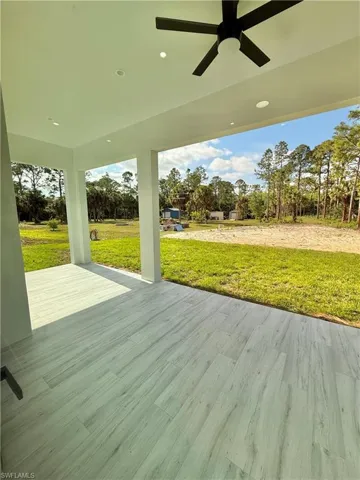 Wooden terrace with ceiling fan and a lawn
