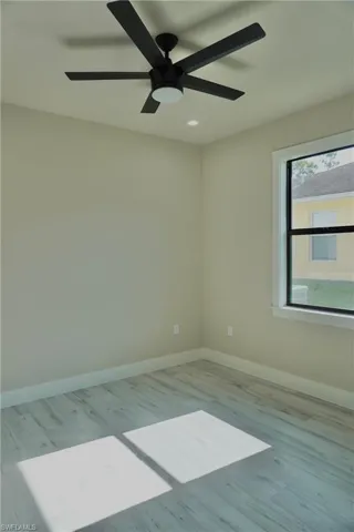 Spare room with recessed lighting, wood finished floors, baseboards, and ceiling fan