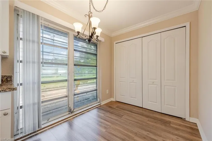 Unfurnished dining area featuring light hardwood / wood-style floors, a notable chandelier, crown molding, and a wealth of natural light