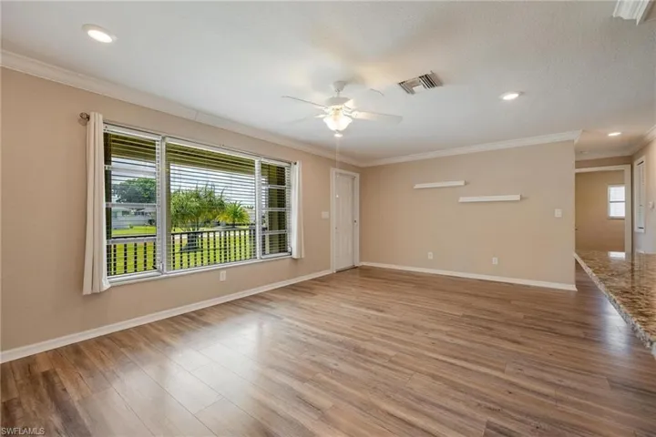 Living room with crown molding and vinyl plank flooring