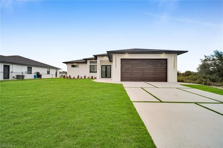 Prairie-style house featuring concrete driveway, a garage, and stucco siding