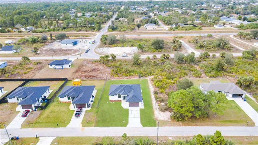 Aerial view of property and surrounding area with nearby suburban area