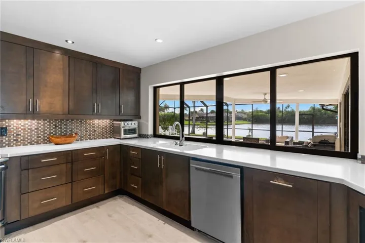Kitchen featuring dark brown cabinets, dishwasher, tasteful backsplash, light wood-style floors, and recessed lighting