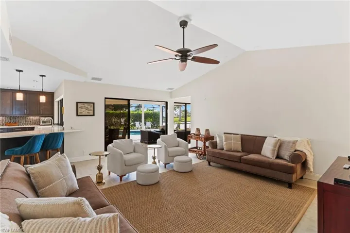 Living area with lofted ceiling, light wood-type flooring, and ceiling fan