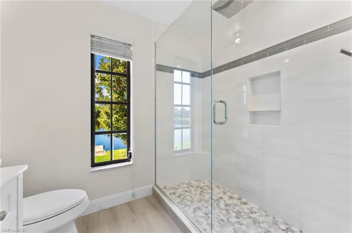 Bathroom with vanity, a shower stall, and a water view