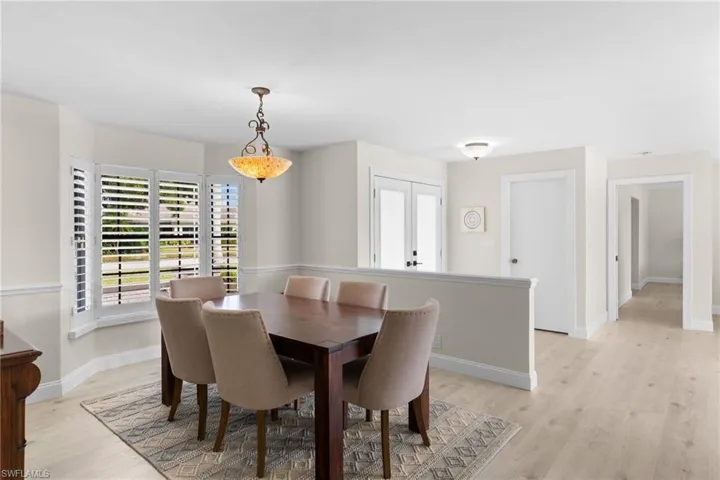 Dining space with healthy amount of natural light, light wood-style flooring, and french doors