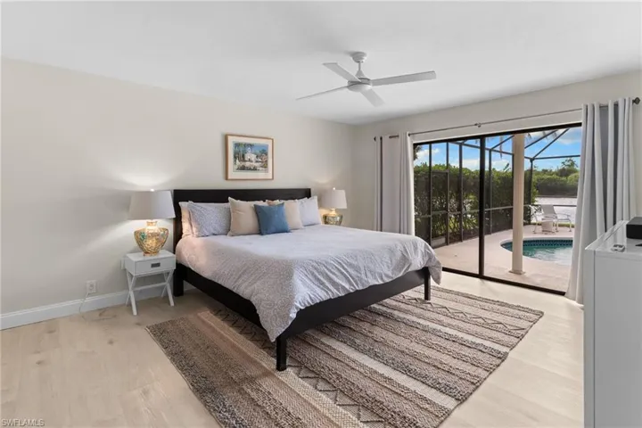 Bedroom featuring access to outside, light wood-style floors, ceiling fan, and a sunroom