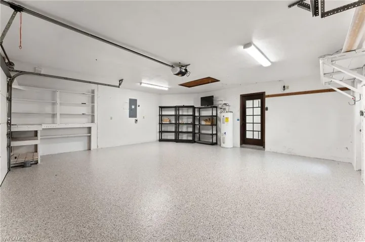 Garage featuring water heater and electric panel