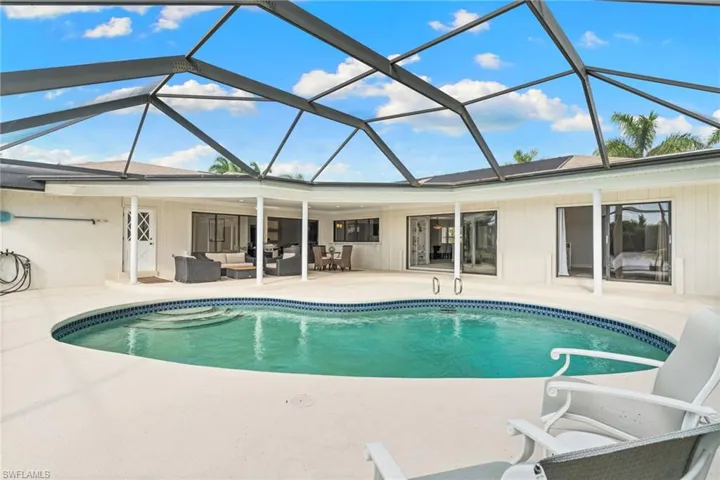 Swimming pool featuring a sunroom, outdoor lounge area, a patio, and glass enclosure