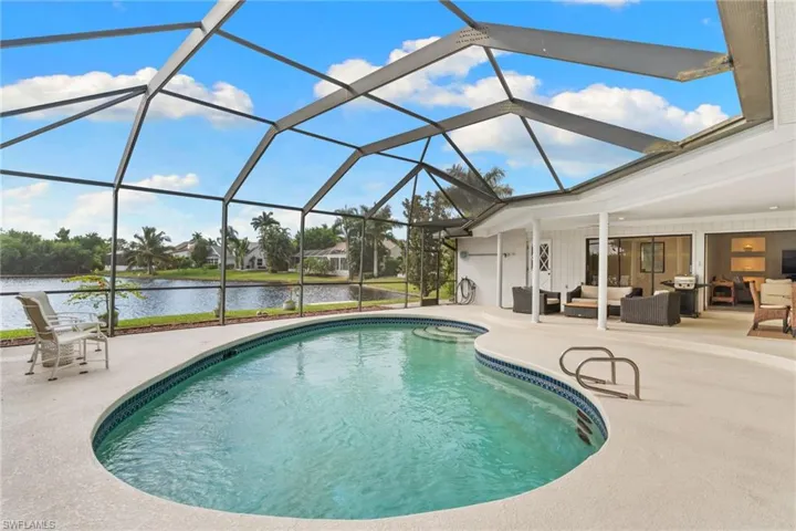 Swimming pool with outdoor lounge area, a sunroom, a lanai, a water view, and a patio area