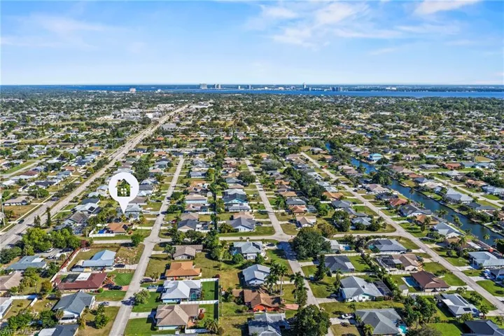 Aerial view of property and surrounding area featuring nearby suburban area