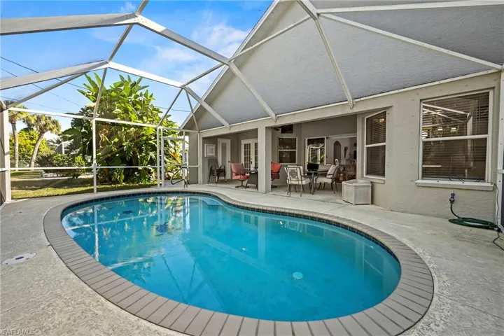 Swimming pool with a patio, a sunroom, and a lanai
