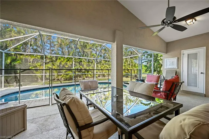 Sunroom / solarium featuring a patio area, vaulted ceiling, ceiling fan, and outdoor dining area