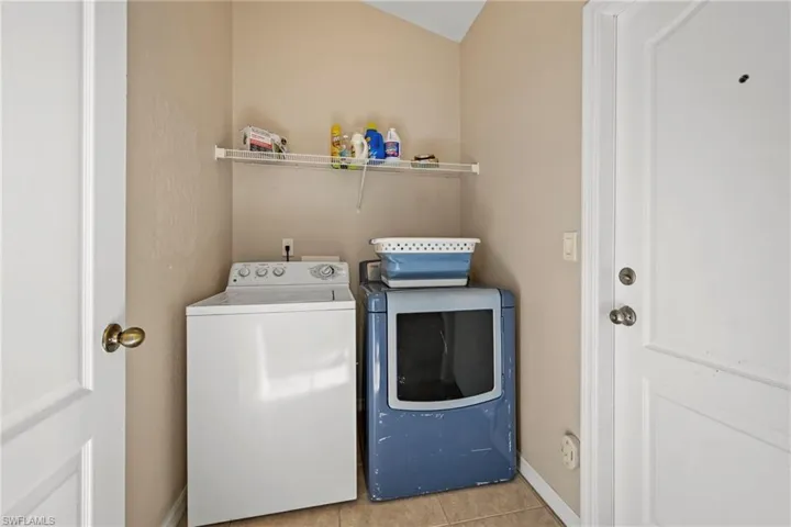 Washroom featuring tile patterned flooring and washer and dryer