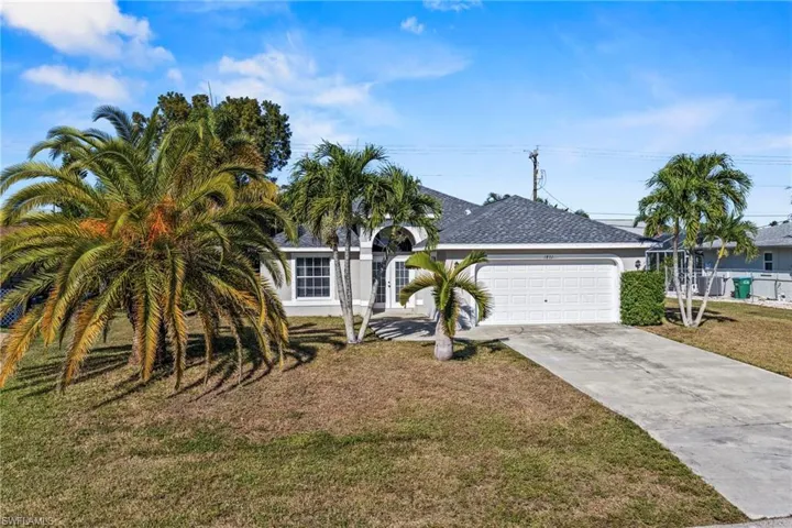 View of front of home with concrete driveway, a front lawn, a shingled roof, and an attached garage