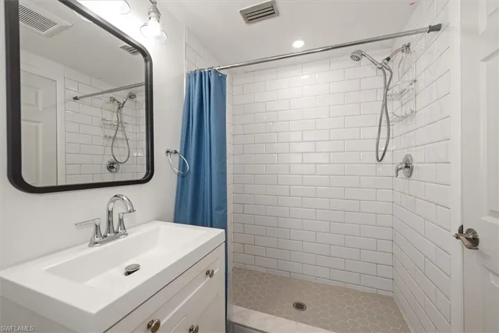 Full bath featuring a stall shower, vanity, and recessed lighting