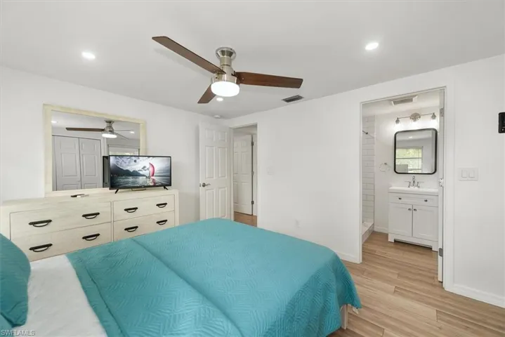 Bedroom featuring light wood finished floors, recessed lighting, a ceiling fan, and ensuite bathroom