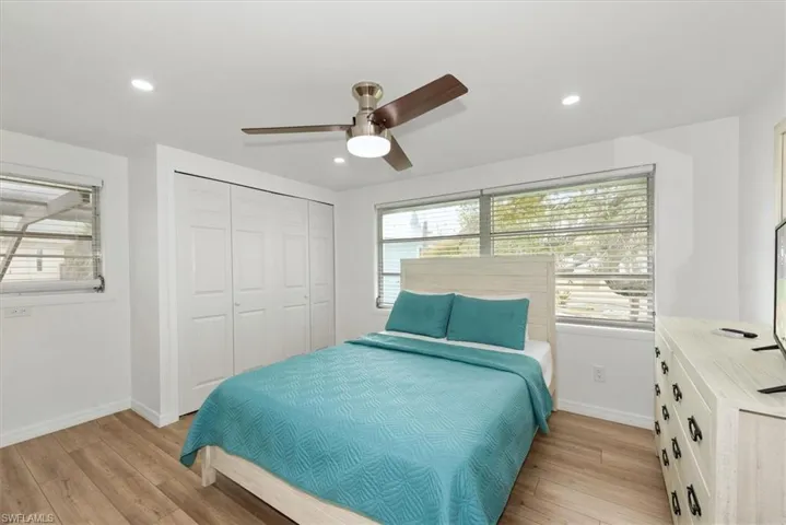 Bedroom with light wood finished floors, a closet, a ceiling fan, and recessed lighting