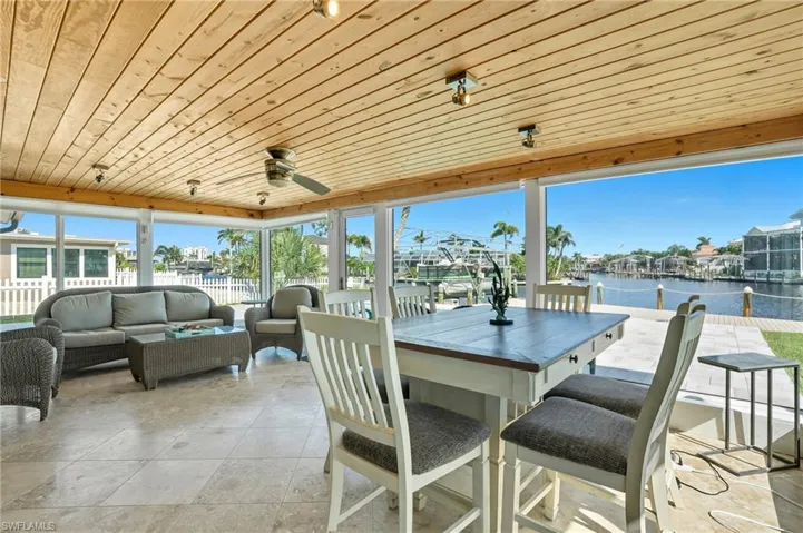 View of patio featuring a water view, ceiling fan, and outdoor lounge area - Virtually Edited Image
