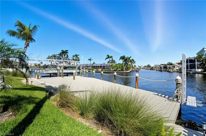 Dock featuring a water view and boat lift - Virtually Edited Image