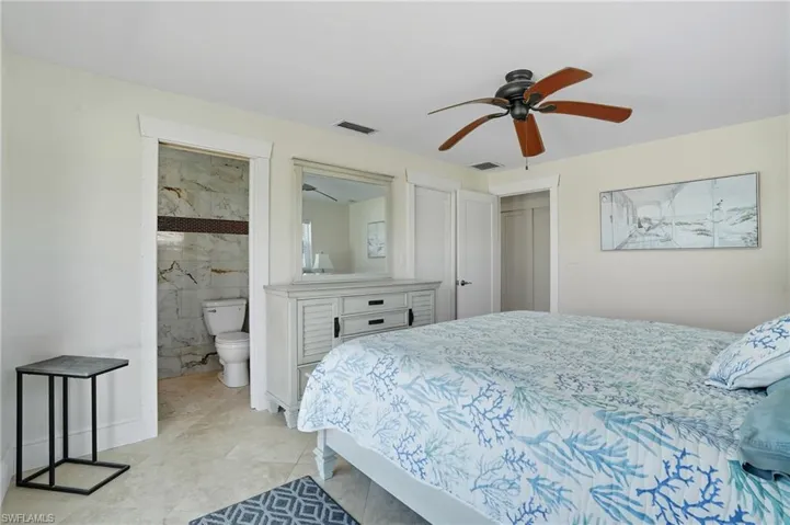 Bedroom featuring a ceiling fan and ensuite bath - Virtually Edited Image