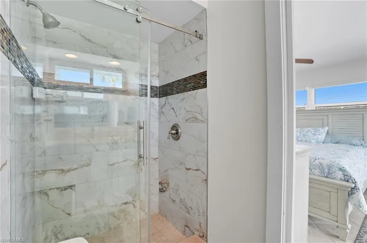 Bathroom with a marble finish shower and connected bathroom - Virtually Edited Image