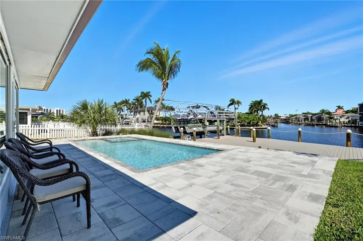 View of swimming pool with a water view, a dock, and a patio area - Virtually Edited Image