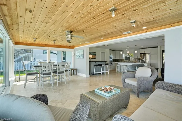 Living room featuring wood ceiling, a ceiling fan, and recessed lighting - Virtually Edited Image