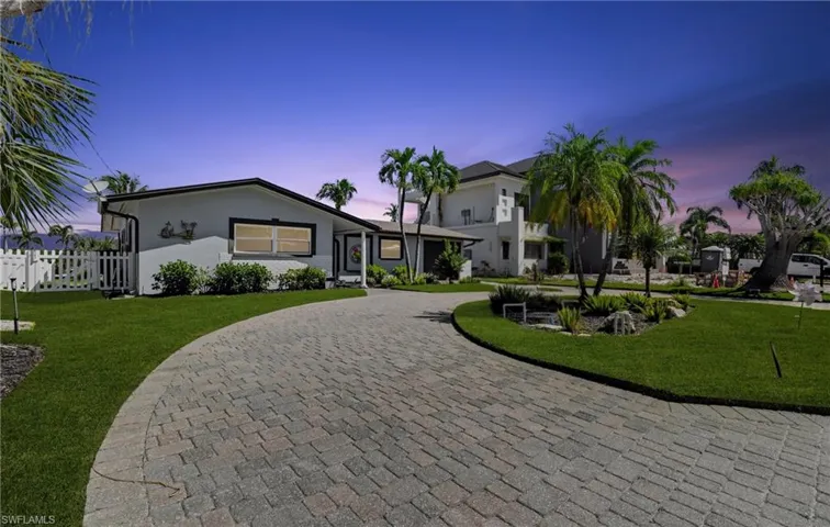 Single story home featuring curved driveway and stucco siding - Virtually Edited Image