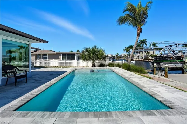 View of pool featuring a patio area and a water view - Virtually Edited Image