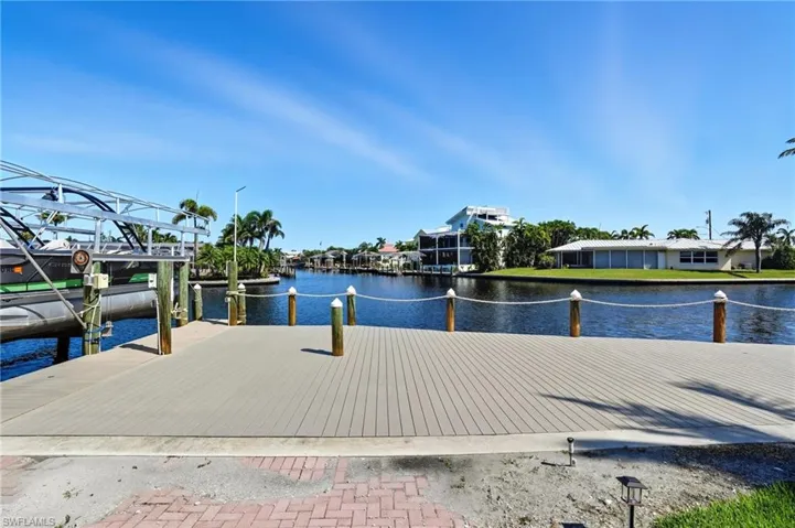 Dock area featuring a water view and boat lift - Virtually Edited Image