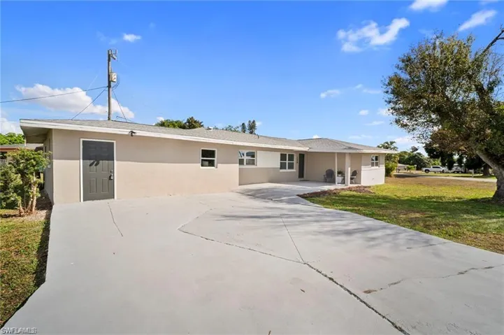 Ranch-style residence featuring a stucco exterior and a gray-painted concrete driveway