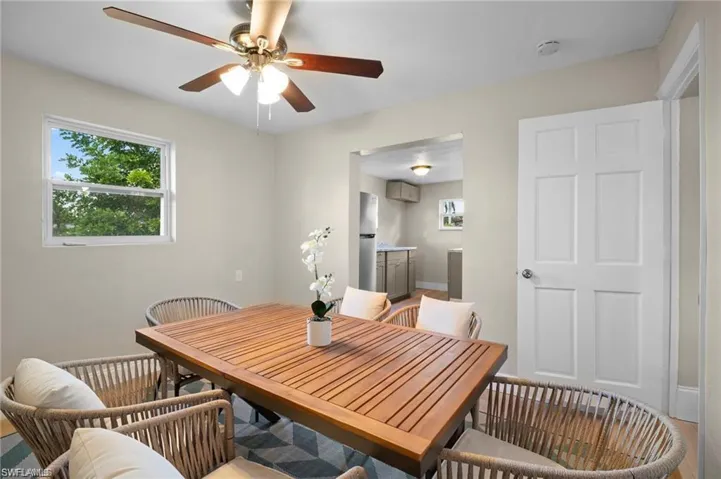 Bright interior room featuring a ceiling fan with integrated lighting, a white framed window, and a paneled white interior door
