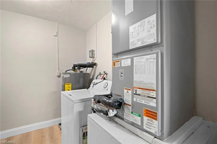 Dedicated utility area featuring a water heater, top-load washing machine, and HVAC system with exposed ductwork