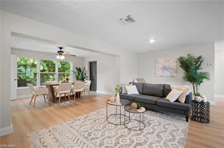 Open-concept living area featuring wood-finish flooring, recessed lighting, and a neutral color palette