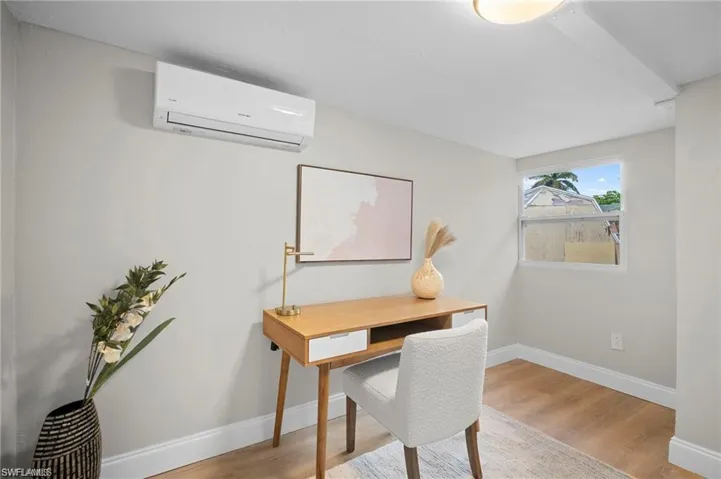 Room featuring a window, wood-finish flooring, and white baseboards