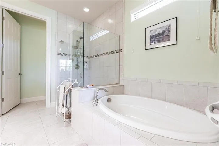 Bathroom with tile patterned flooring and independent shower and bath