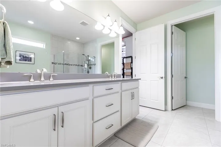 Bathroom with tile patterned flooring, an enclosed shower, and vanity