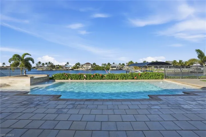 Swimming pool with a water view and a patio area