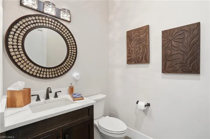 Half bathroom featuring vanity and toilet